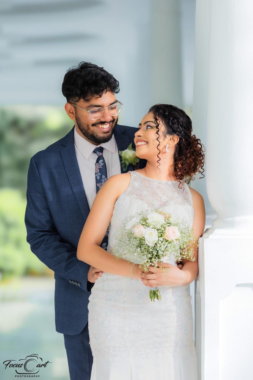 Amanda holding a bouquet with Shanuka beside her